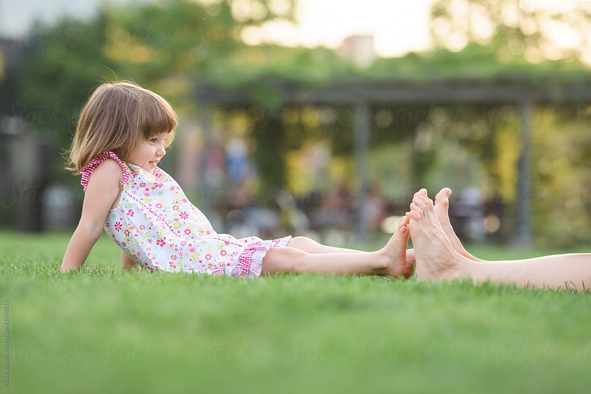 Girl bonding with her older sister sitting on the grass