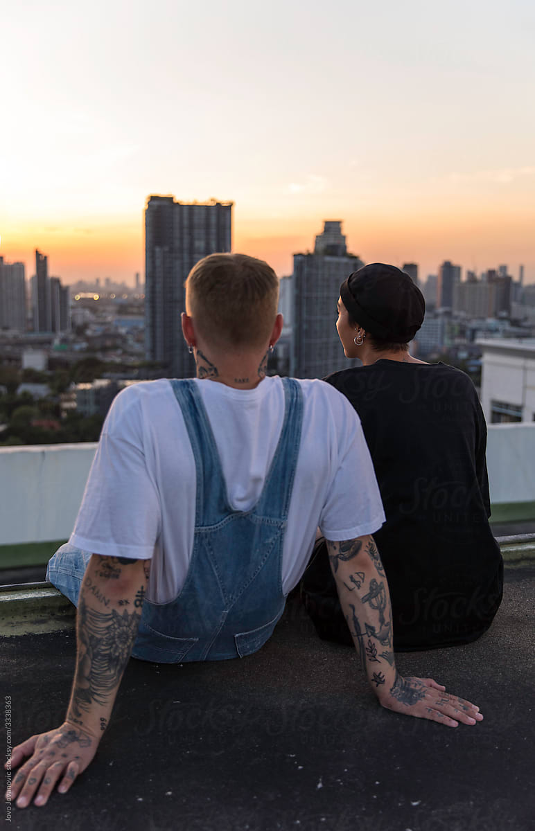 Couple enjoying sunset over city from rooftop