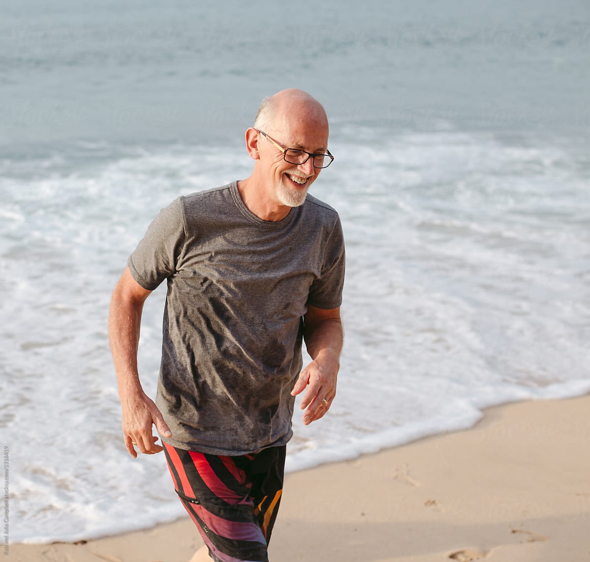 Smiling Older Man Walking On Beach By Stocksy Contributor Rob And
