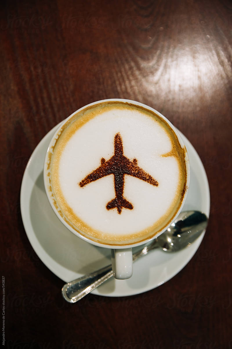 Coffee cup with an airplane made of chocolate powder on top of the foam - Travel concept