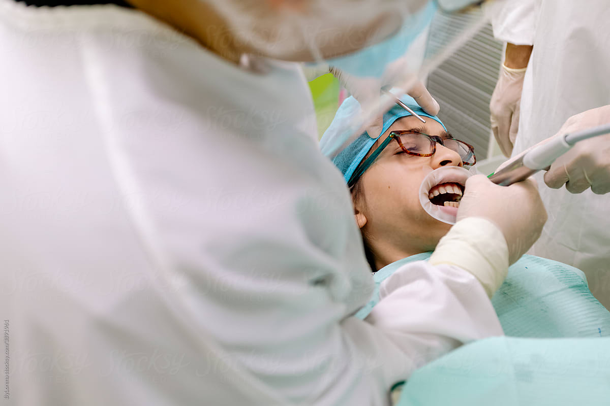Crop dentist healing teeth of mixed race boy