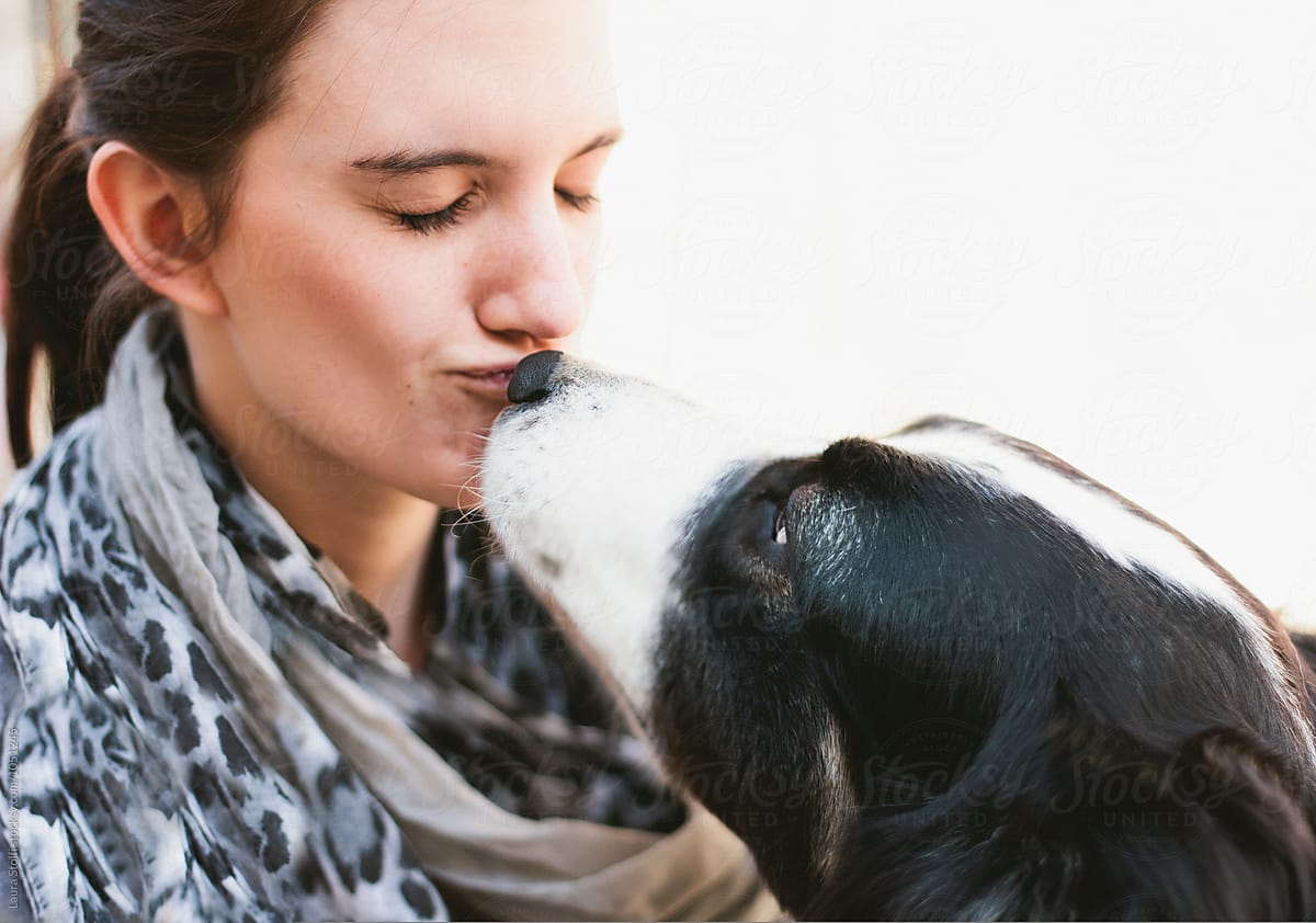 Extreme close up of shepherd dog kissing on the mouth beautiful brunette woman