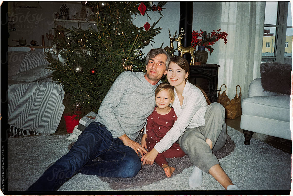 Family photo near Christmas tree in living room, direct flash ugc