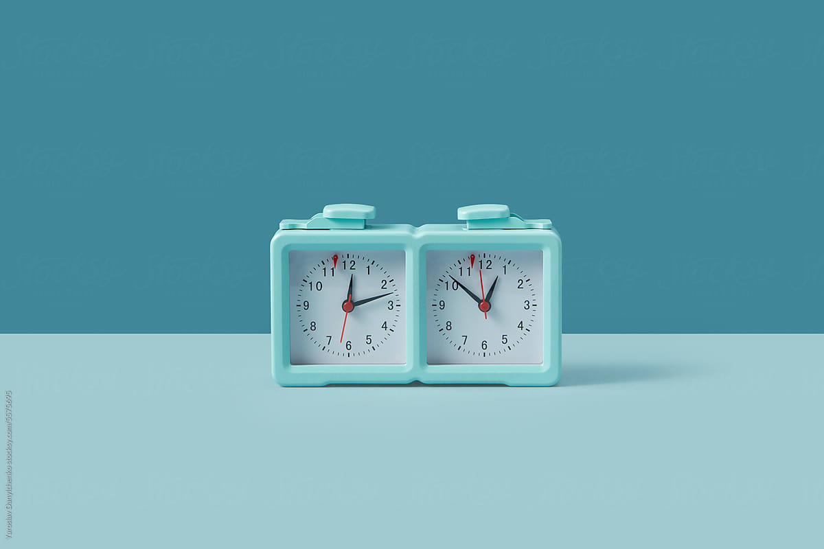 Turquoise colored chess clock standing on duotone background