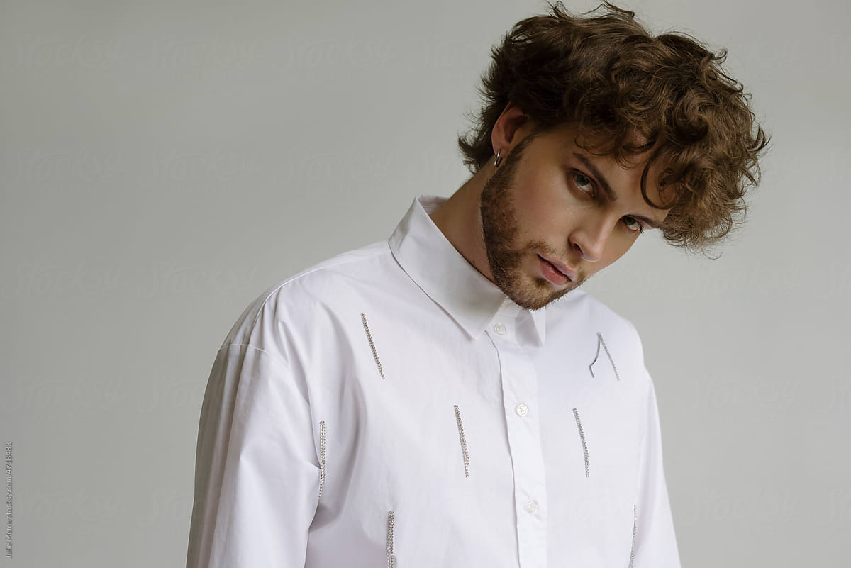 A bearded guy\'s portrait with curly hair in a  stylish white shirt