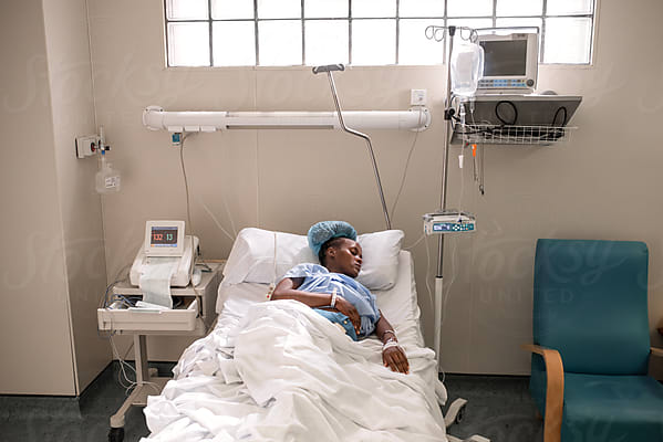 African Mother Breastfeeding Baby In Hospital Room by Stocksy