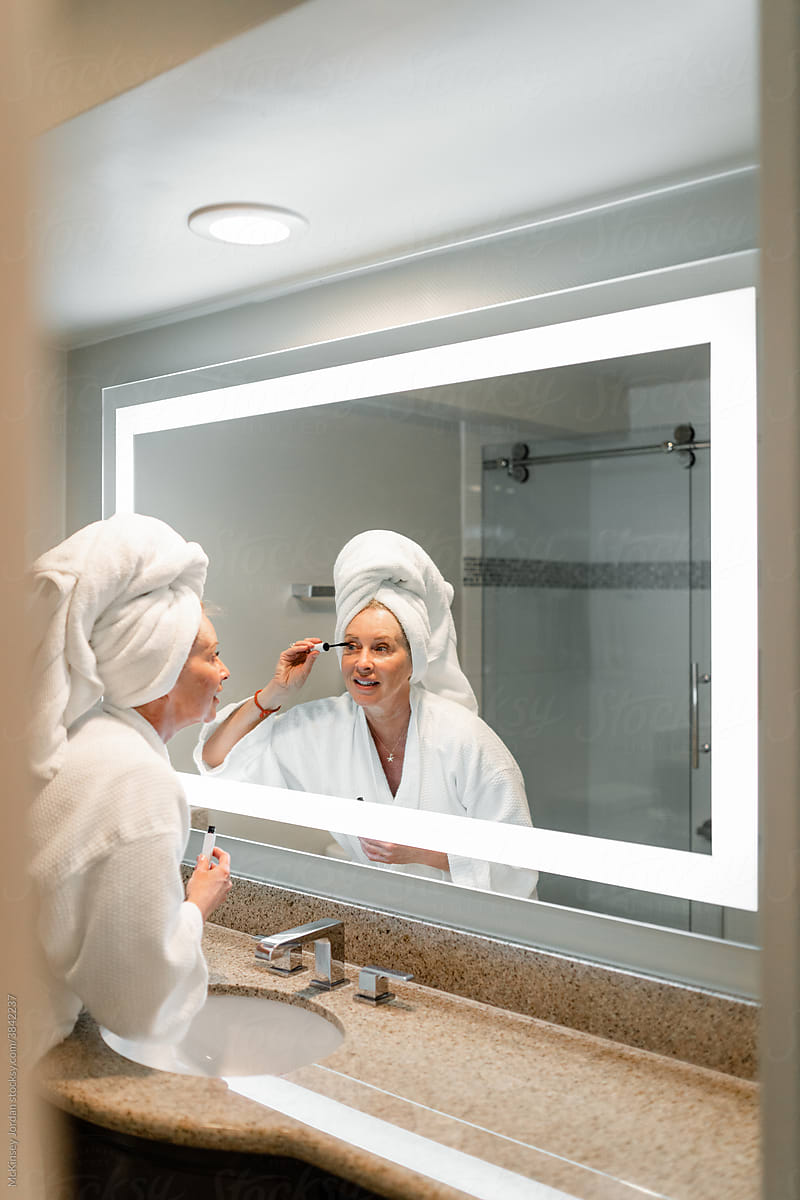 Woman Applies Mascara in Bathroom Mirror