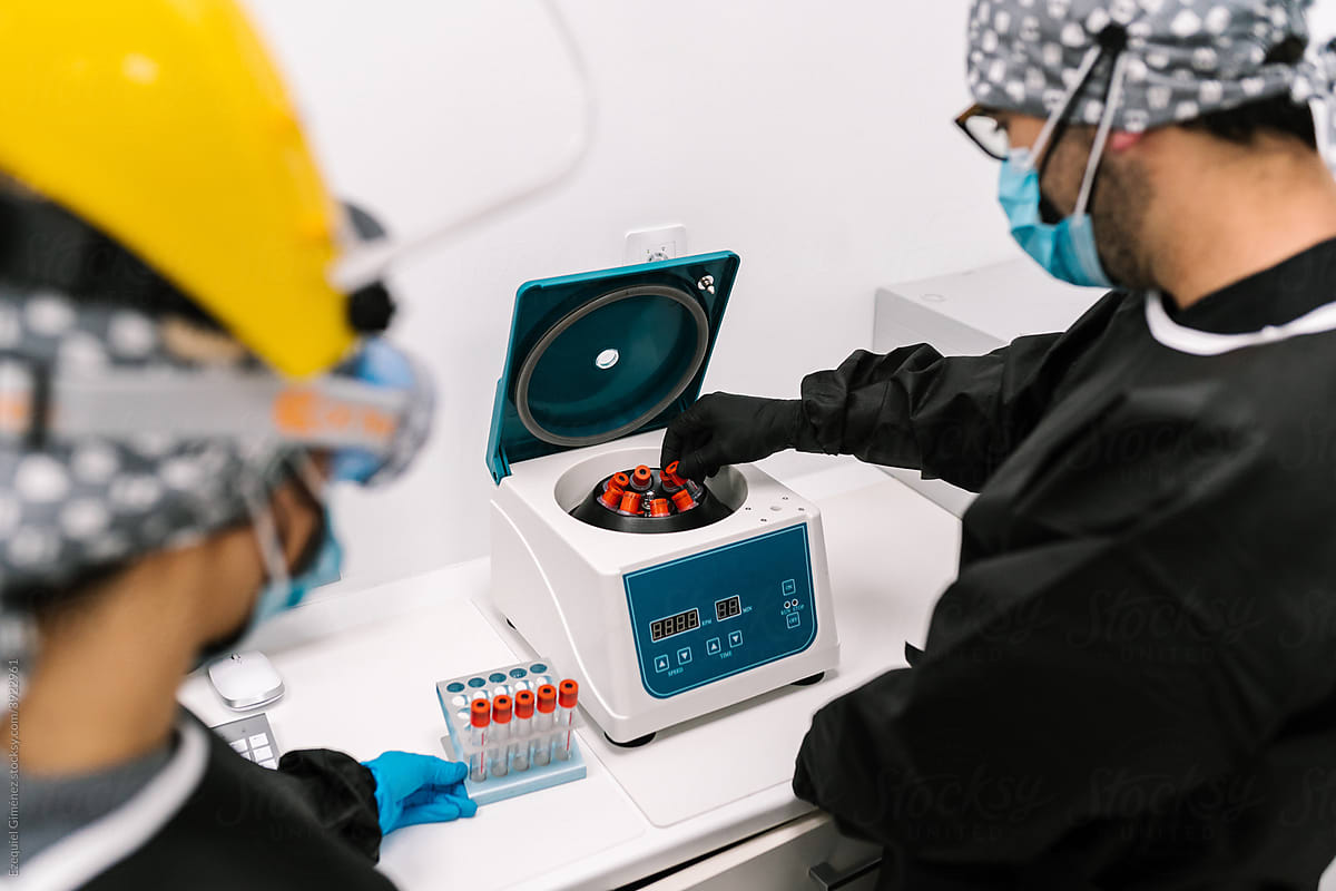 Physicians putting blood samples in the centrifuge