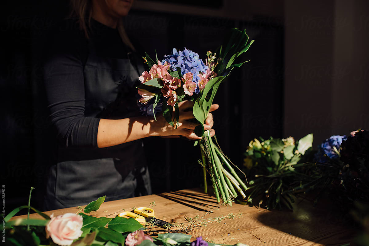 Anonymous shot of a florist woman packing the flower bouquet