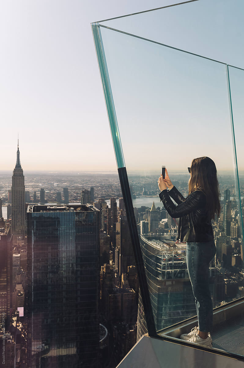 Woman capturing Manhattan skyline from observation deck