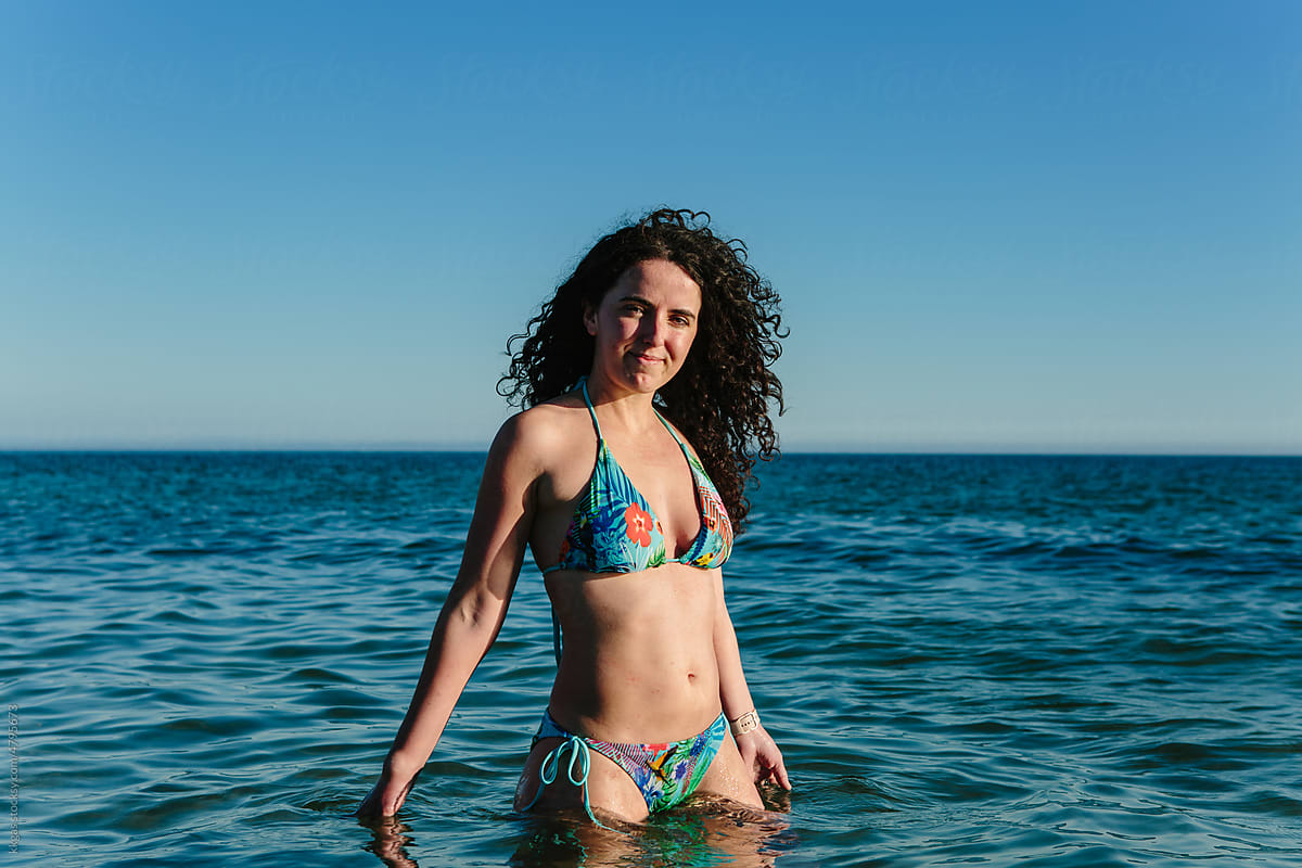 Confident young woman wading in the sea