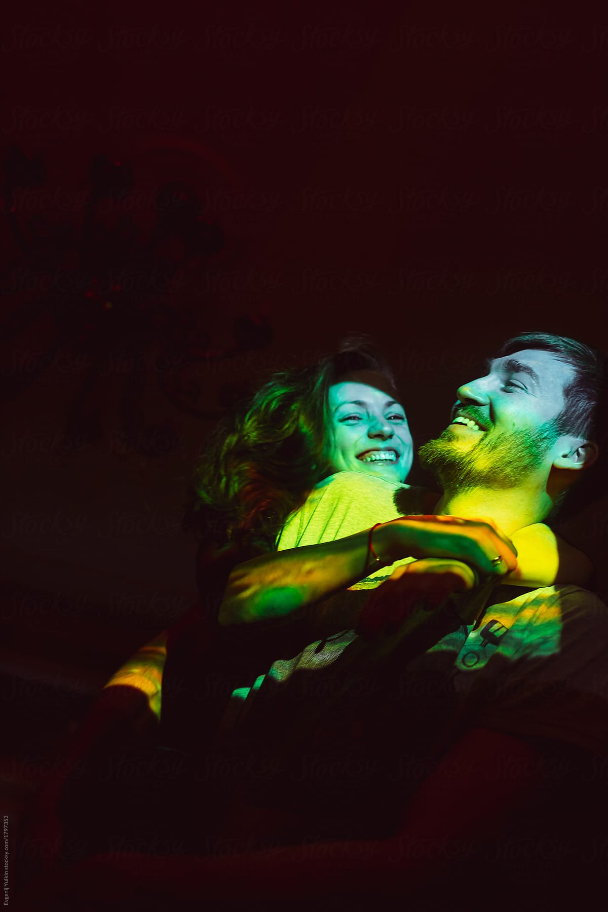 Laughing couple in the beam of projector