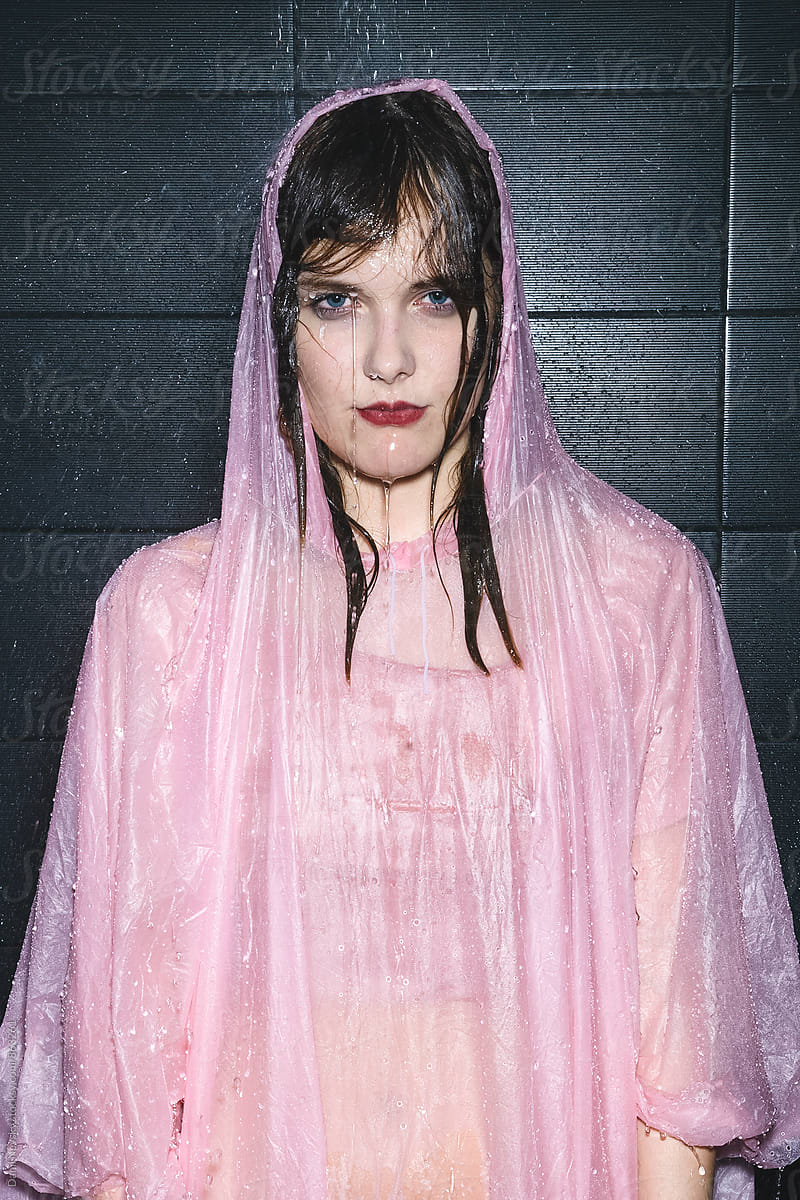 Woman taking shower in pink raincoat