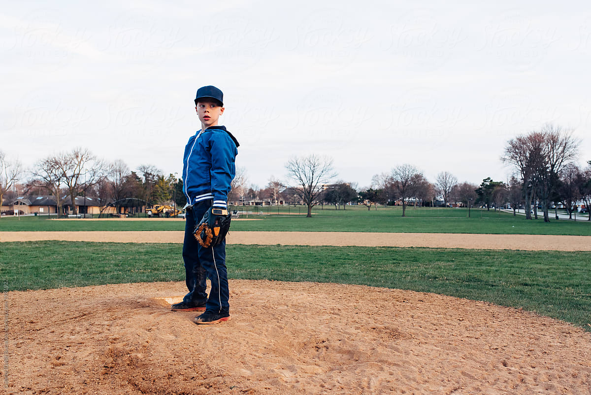 Young boy getting ready to throw a baseball from a field mound