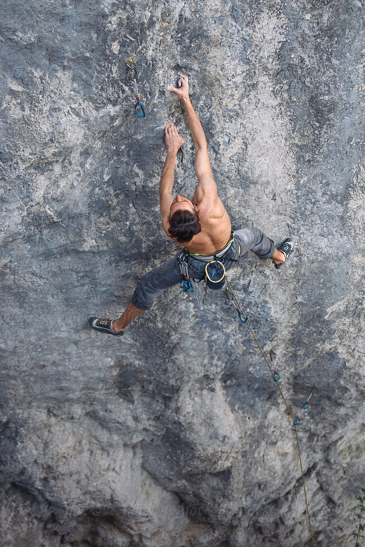 Male climber holding on a single finger hold