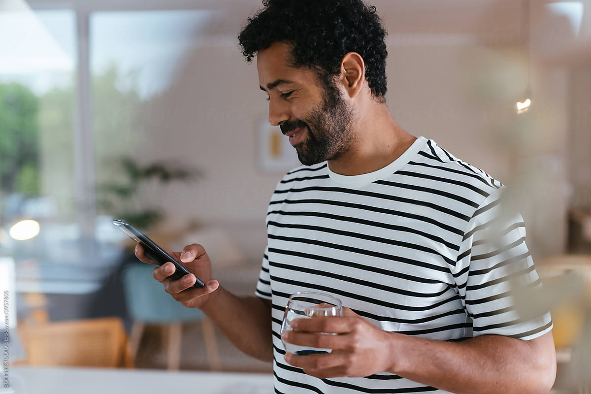 Cheerful man reading message on smartphone