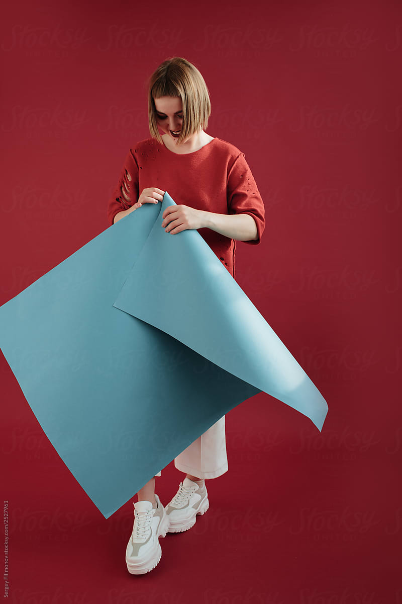 Cheerful woman folding paper sheet