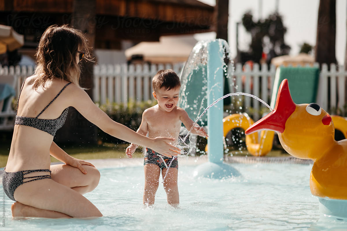 Toddler with mom in outdoor pool.