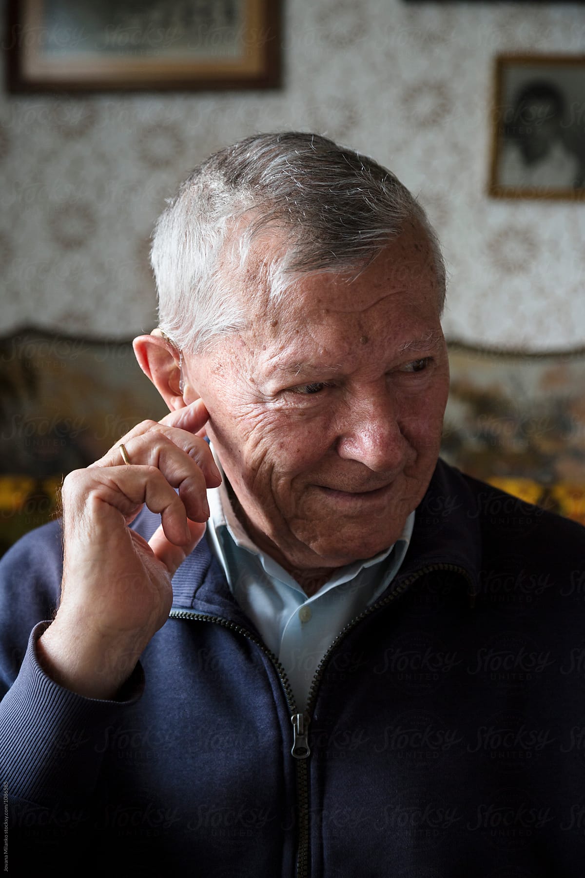 Portrait of a senior man adjusting his hearing device