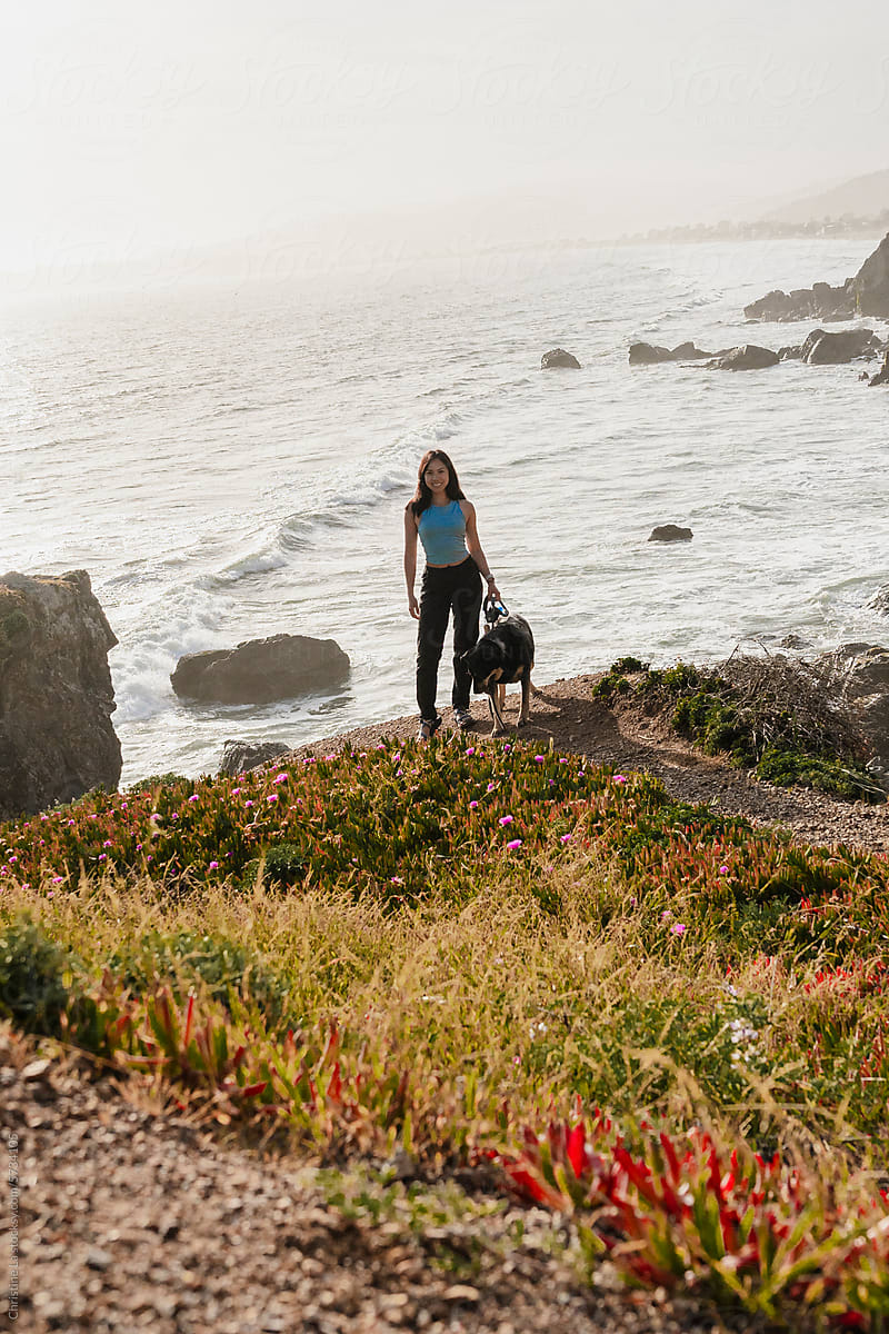 Woman hiking with dog at beach
