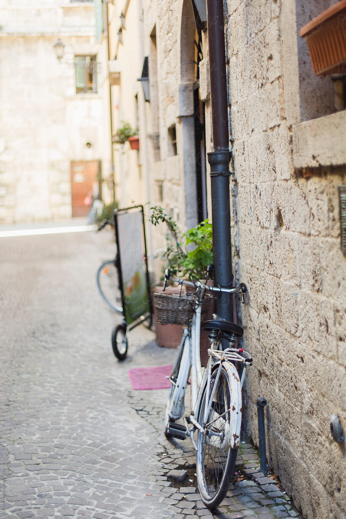 Old-fashioned bike parked close to ancient stone building in Ascoli Piceno, Italy