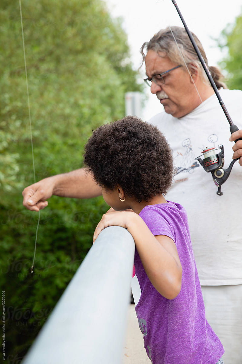 Girl watches as her grandfather pulls on his line