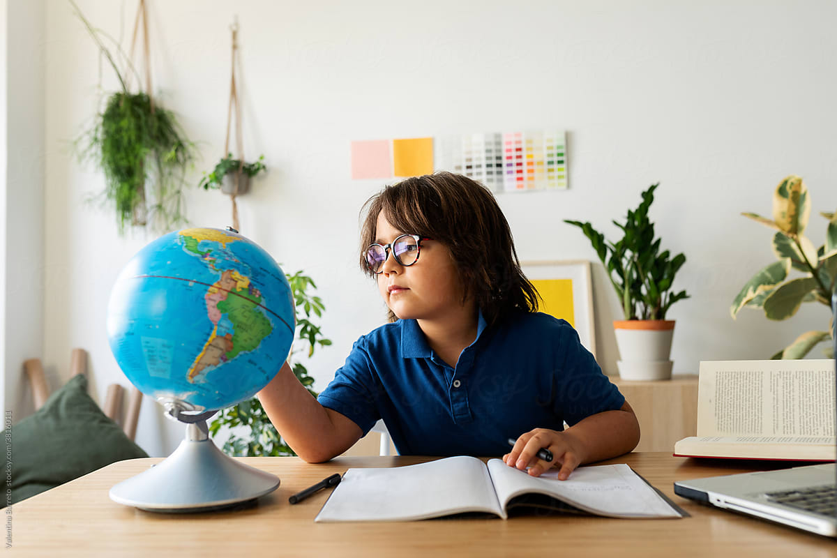 young boy looking globe map