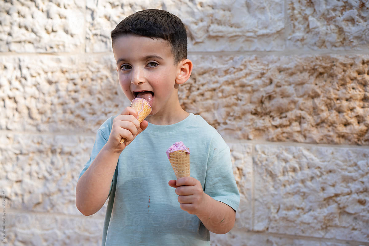 Summer Treat. Boy on Street with Two Ice Cream Cones.