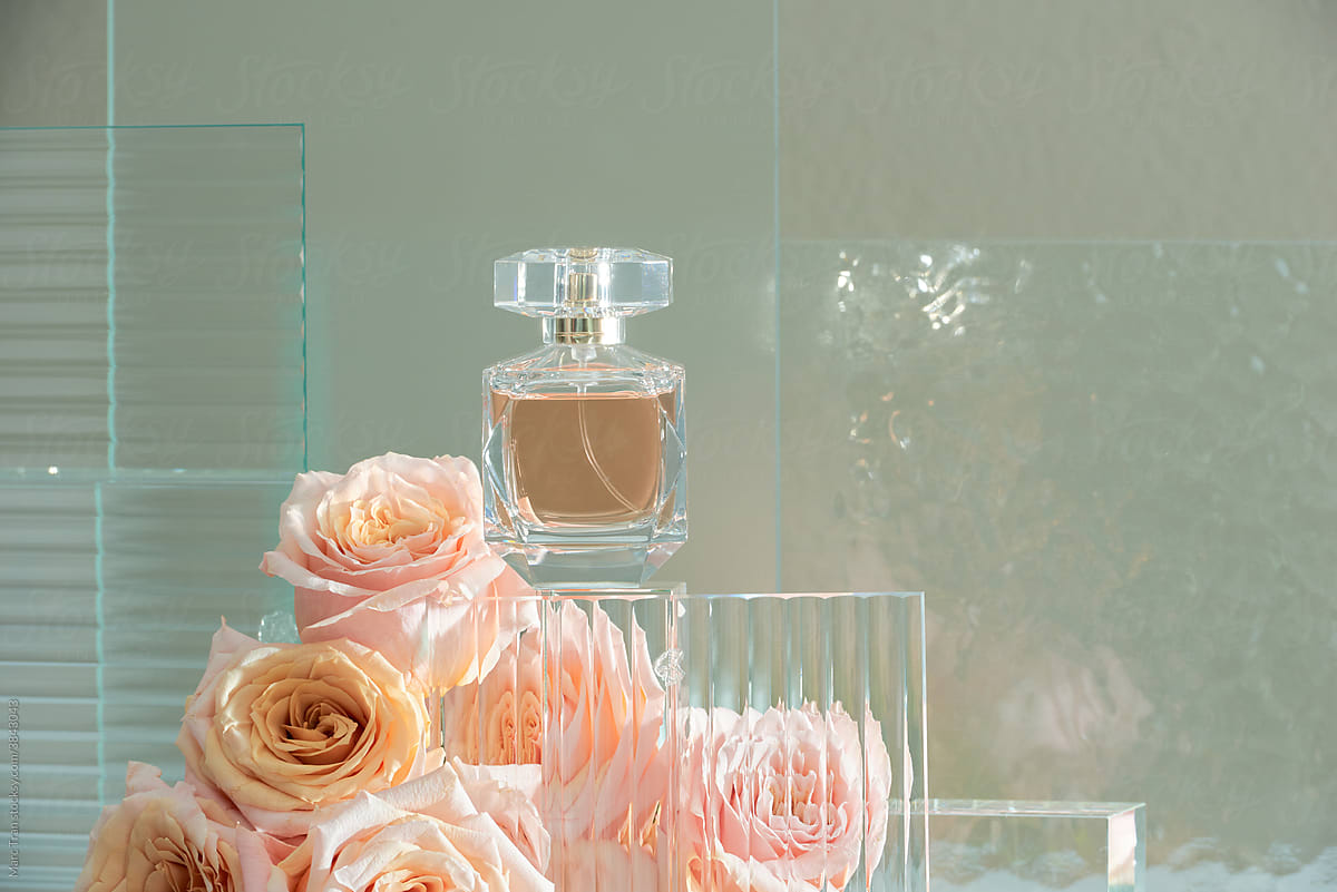 Bottles of perfume with flowers on dark background