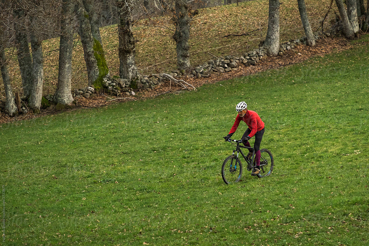 athlete on a mountain bike crossing a meadow