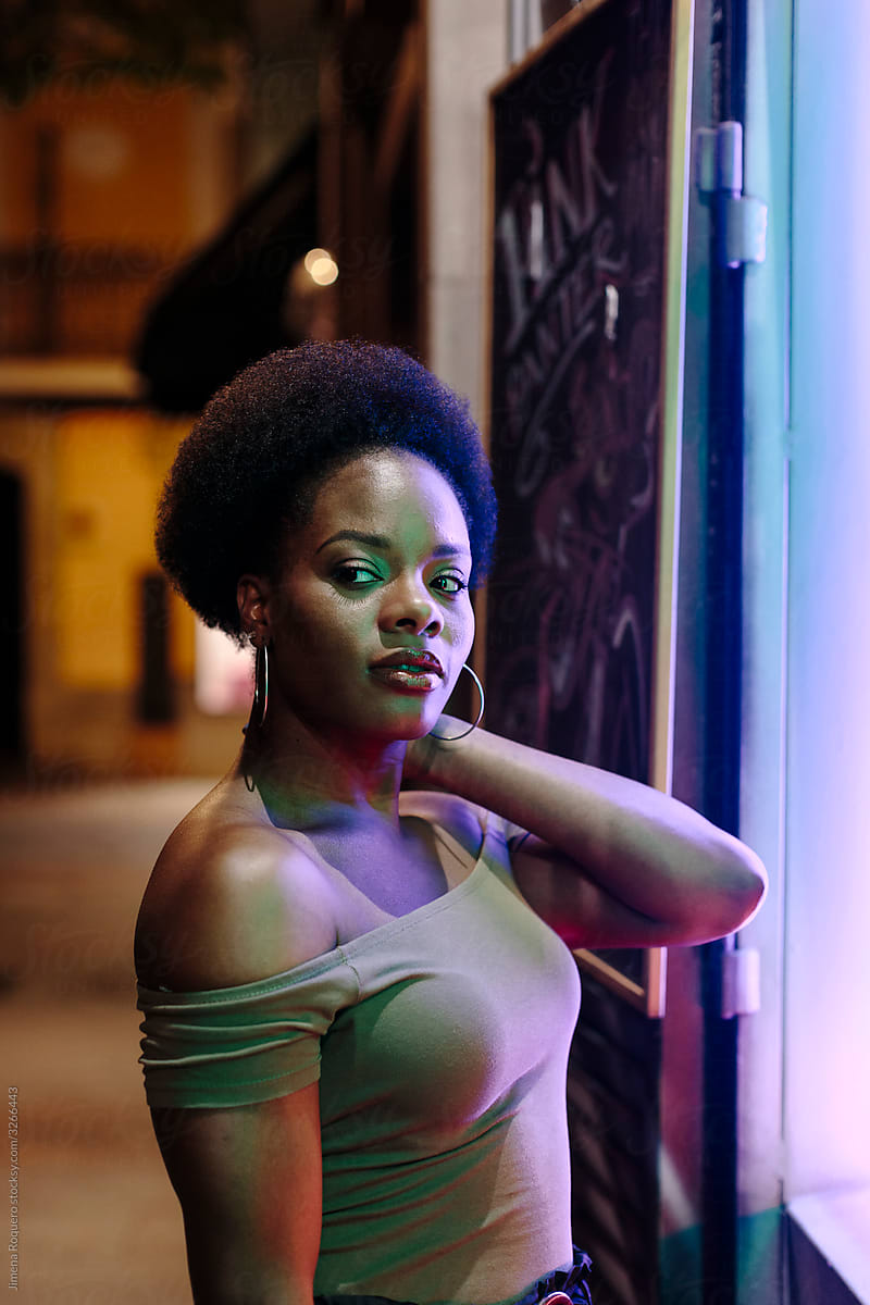 Woman with afro hair in a city street in a summer night