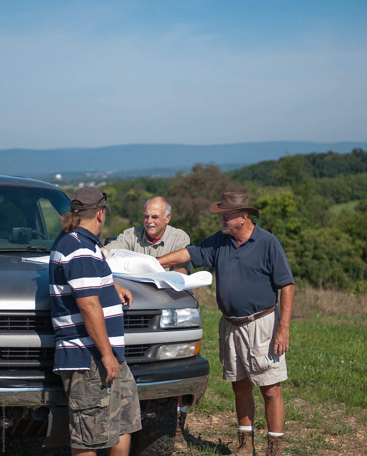 Land Survey Crew Examines Blue Prints on Truck