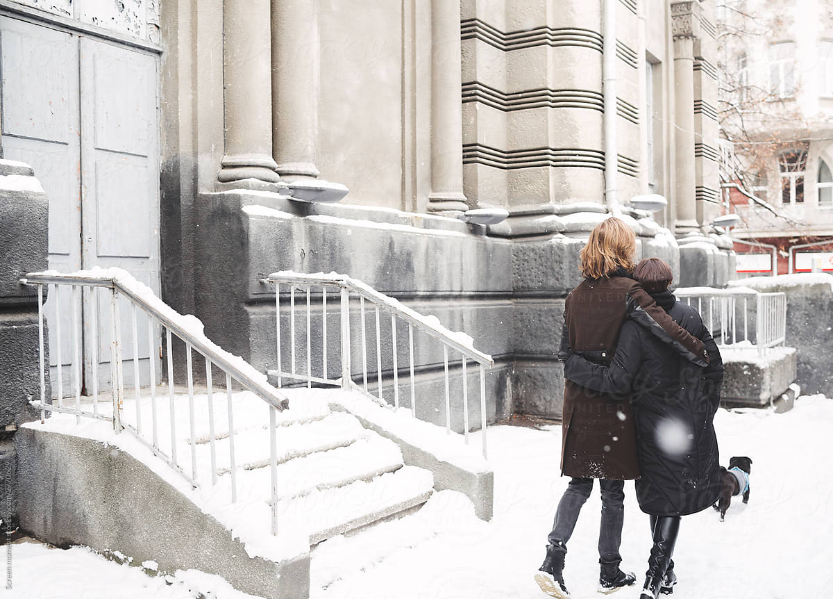 Winter love story, a beautiful stylish young couple. 
 Young hipster couple hugging each other in winter city and walk