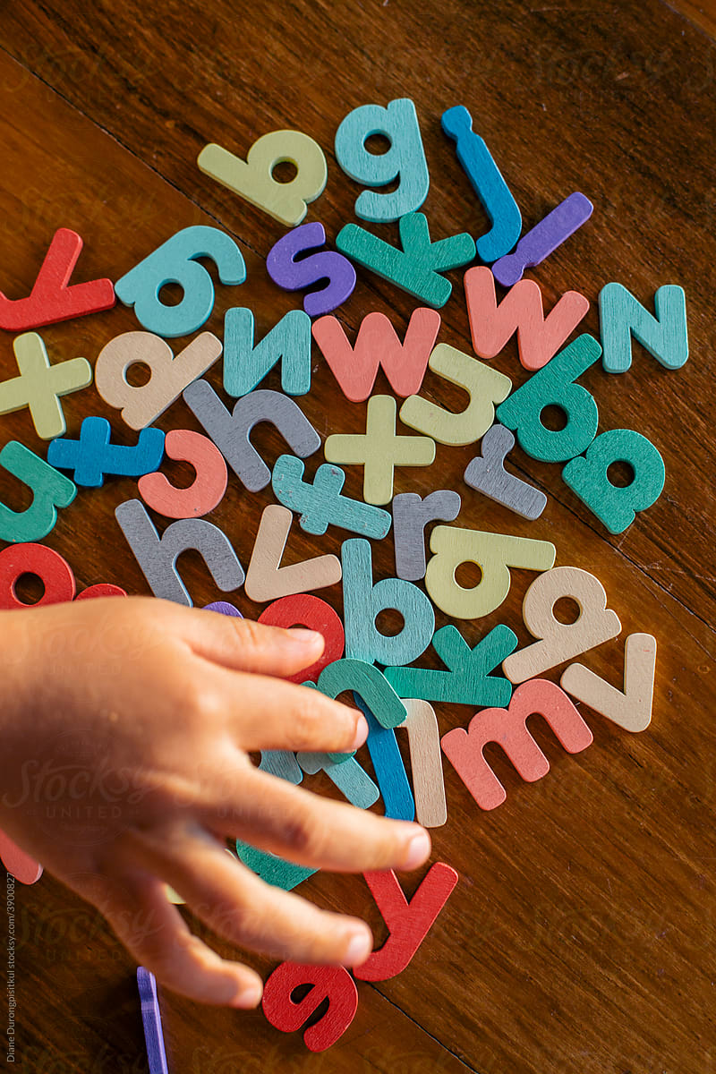 Child\'s Hand Picking Colourful Letter