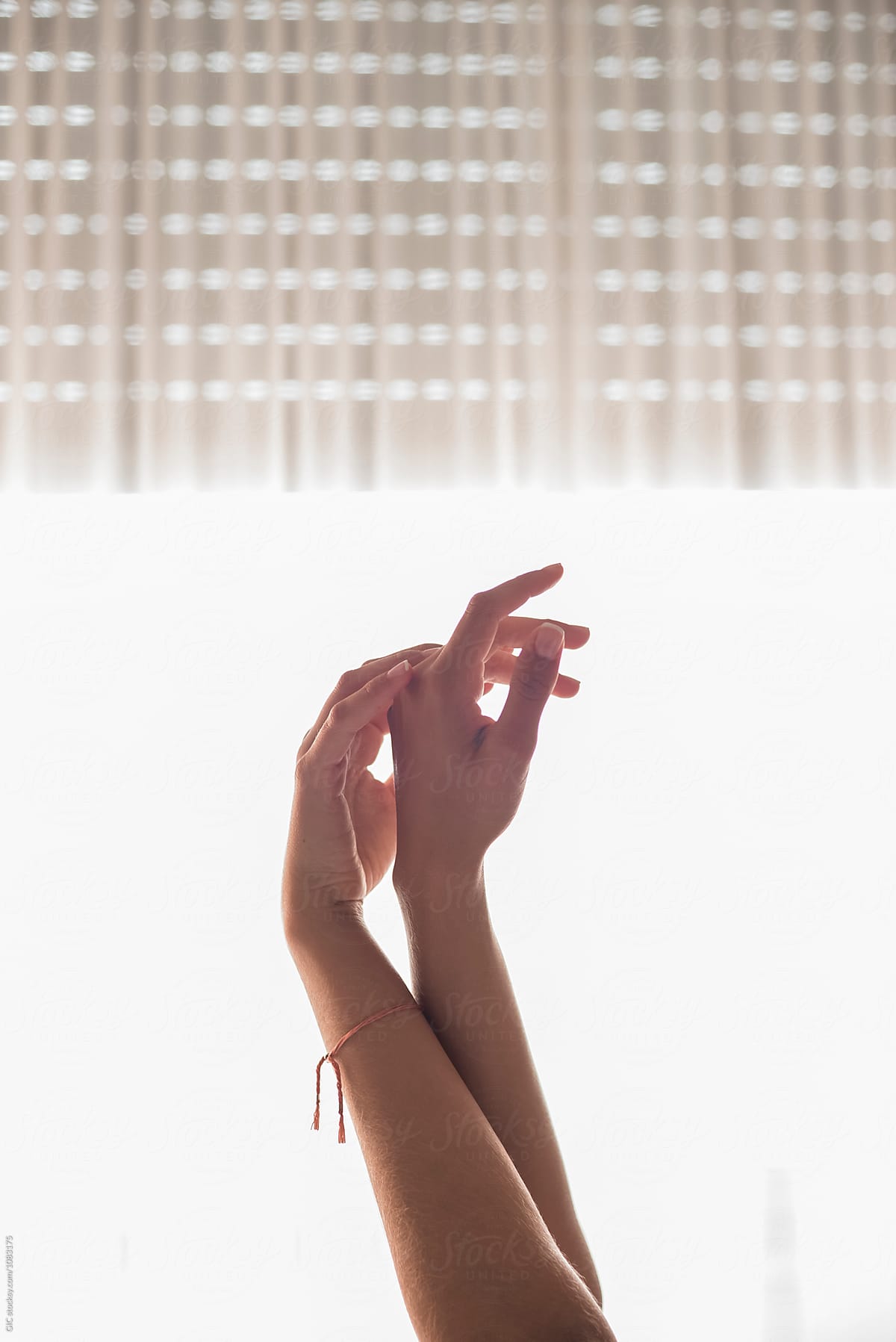 Woman raising hands against a window