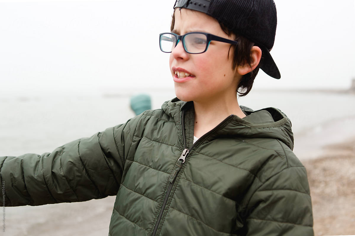 Side profile of boy in glasses and backwards hat