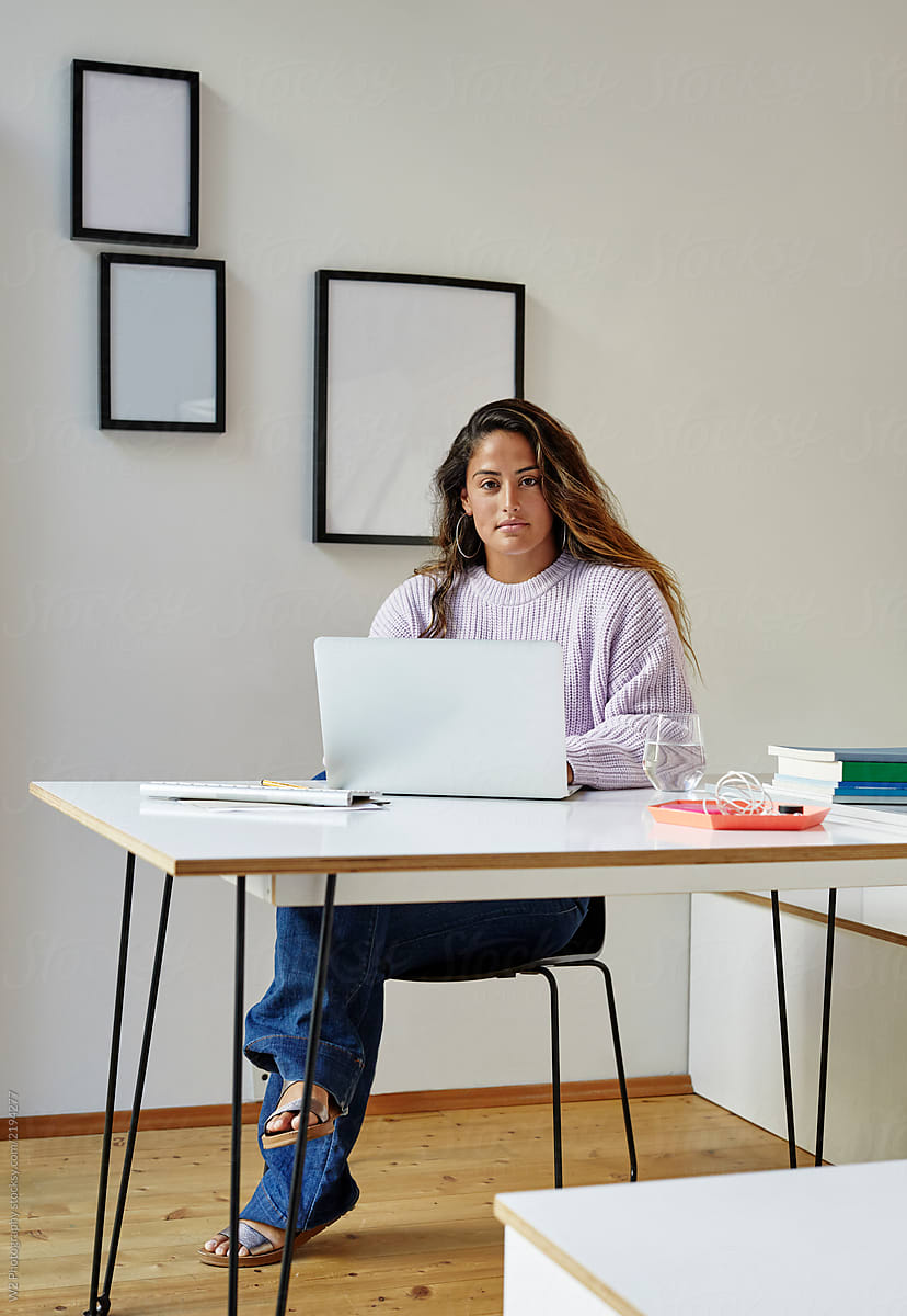 Young professional woman working at a desk in her home office.