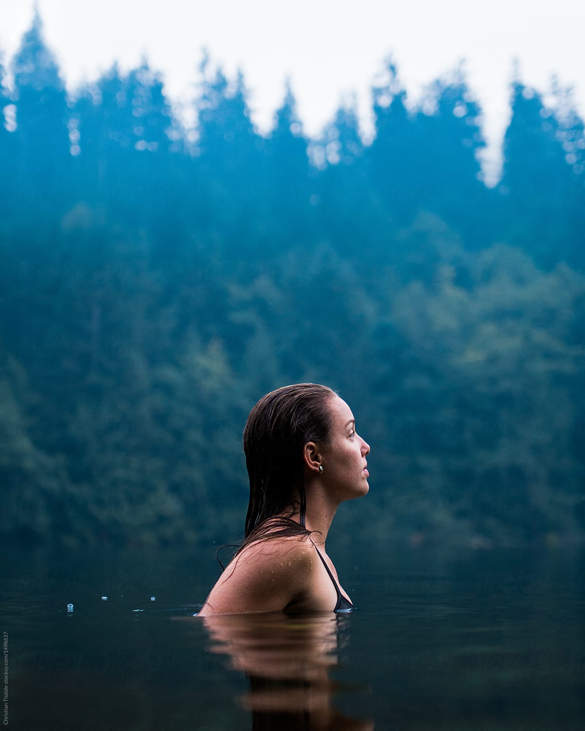 A Young Woman In Chest Deep Water In A Lake On A Smoky Evening By Stocksy Contributor