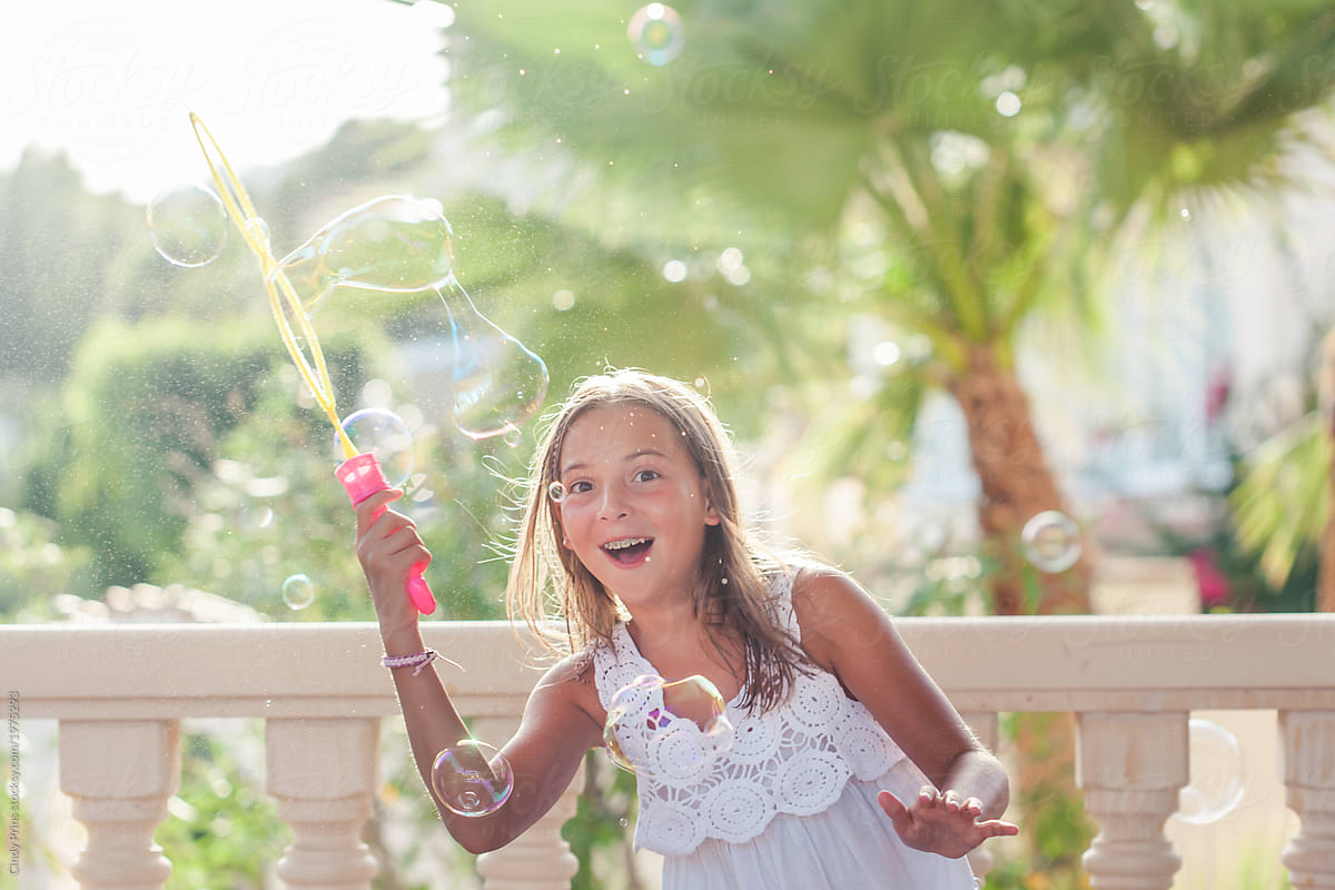 Happy Girl Having Fun With With Soap Bubbles By Stocksy Contributor