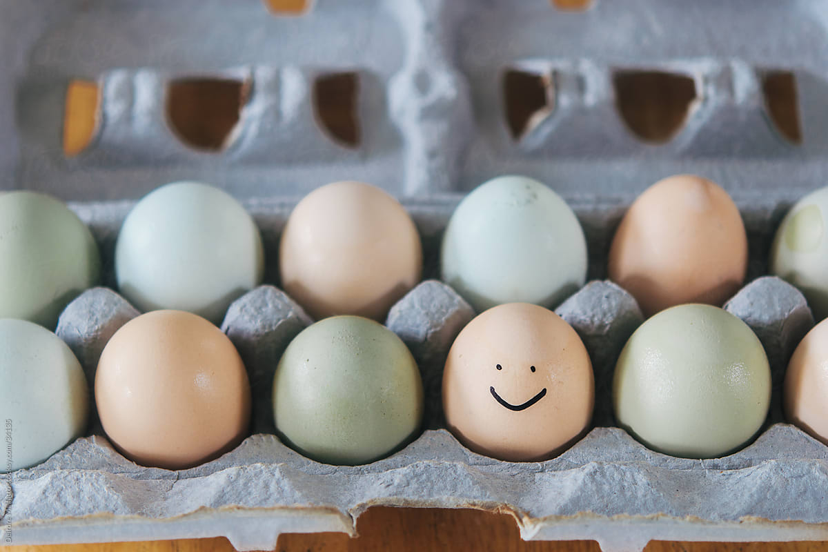 a carton of organic eggs, one with a smiley face
