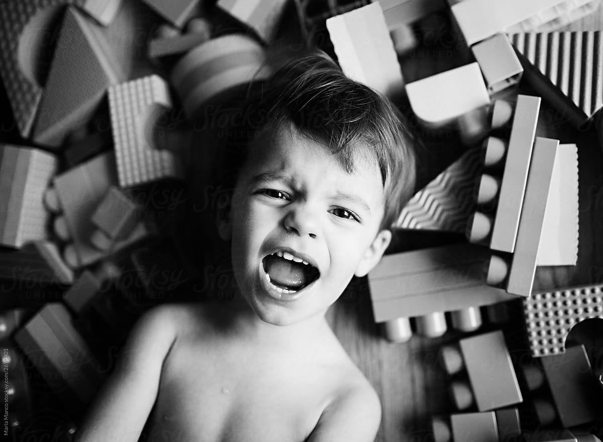 overhead view of upset boy with toy blocks