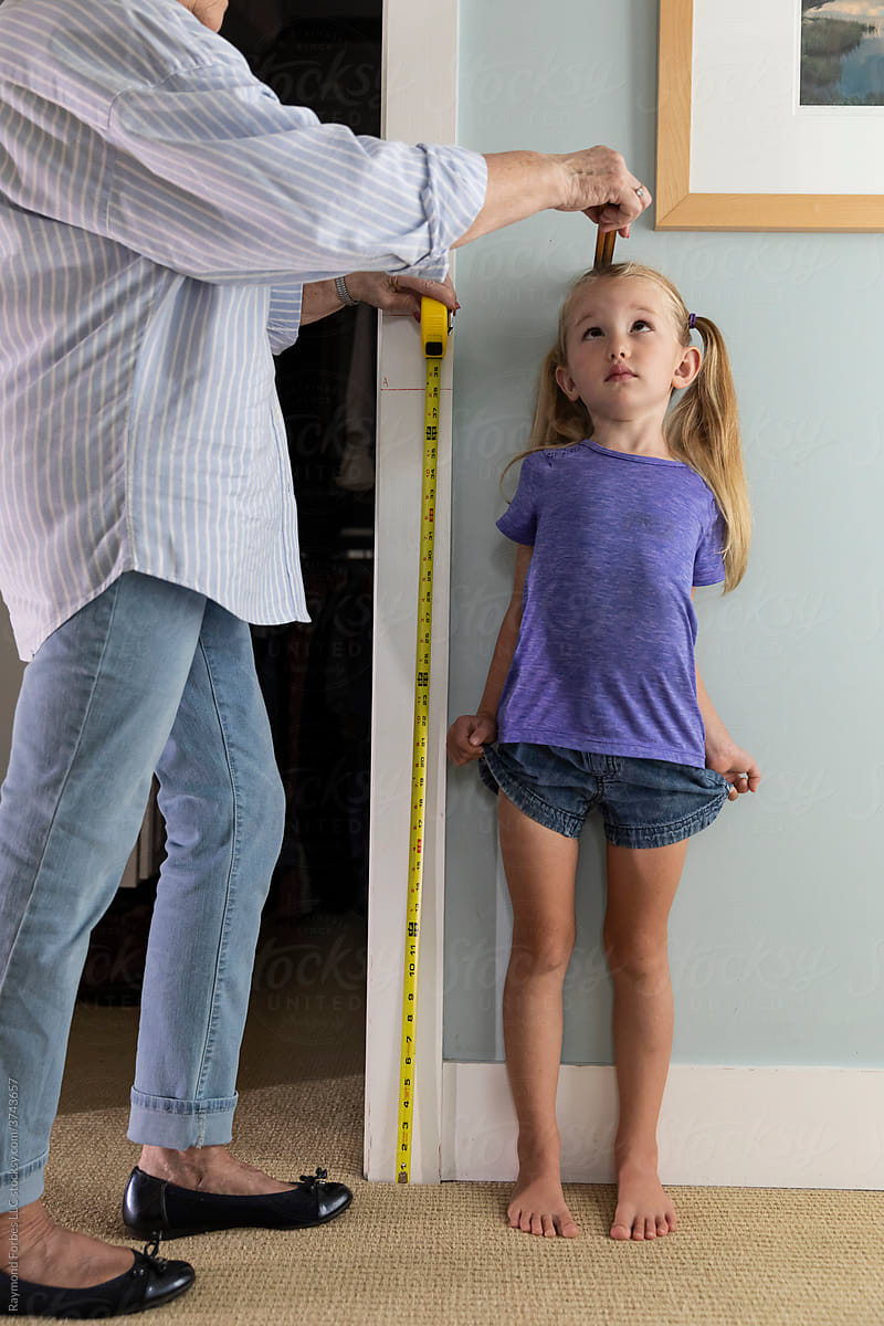 Barefoot Young Girl Measuring her height
