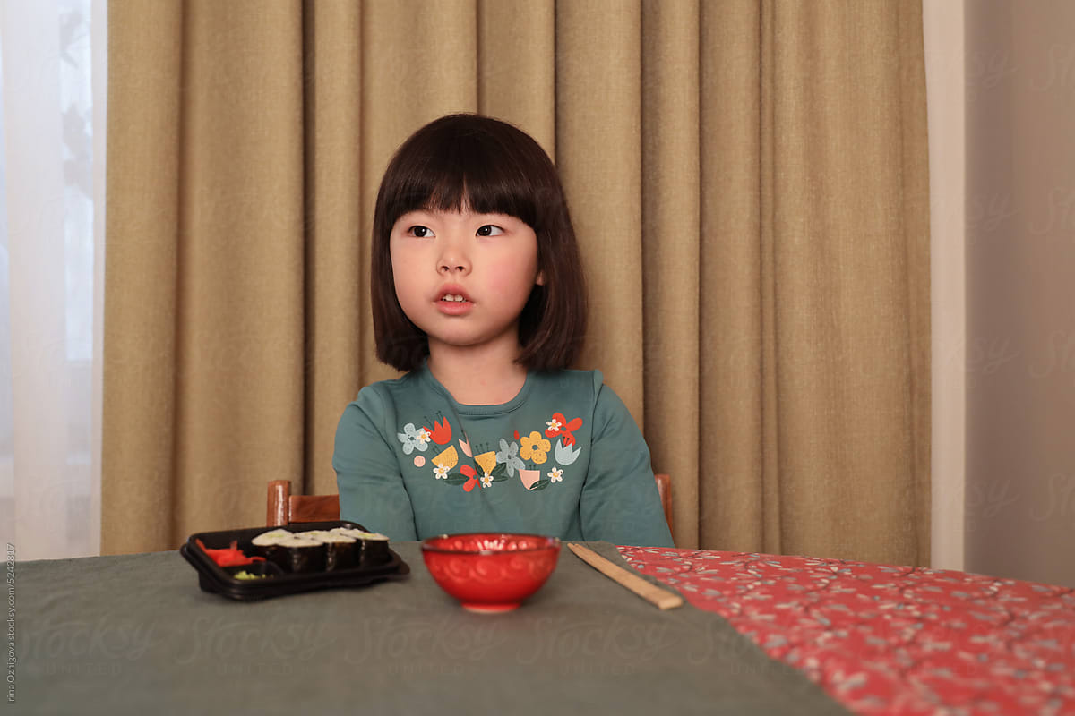 little girl sitting at the table at home