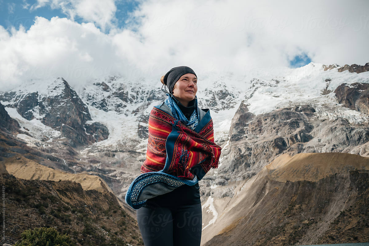 Woman Standing In The Wind, on a high  Mountain wrapped in poncho