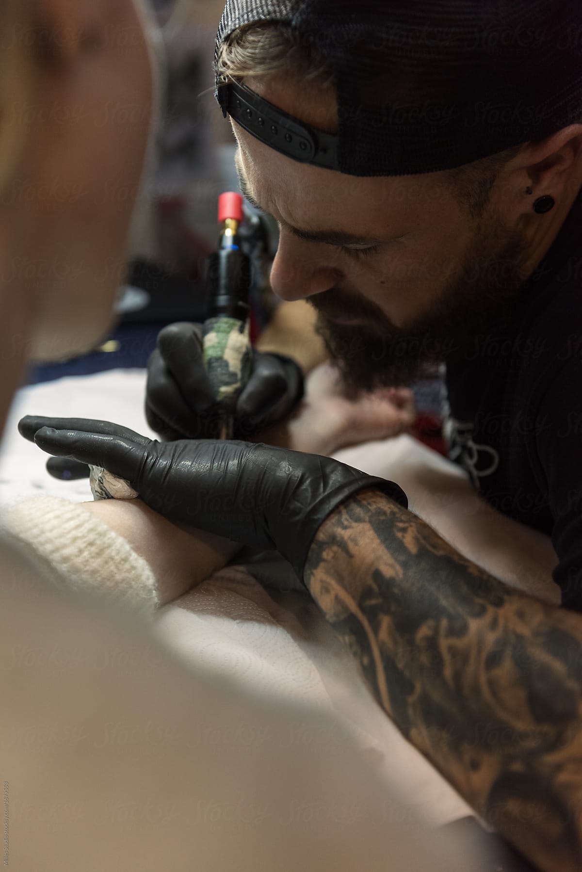 Tattooist working with arm