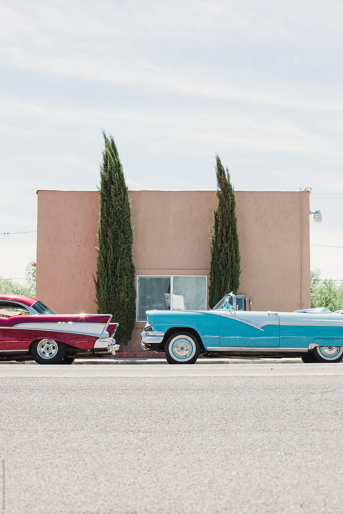 Two vintage cars parked outside a building on the route 66