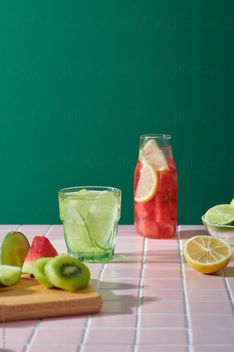 Set of glasses with different refreshing drinks on pink table
