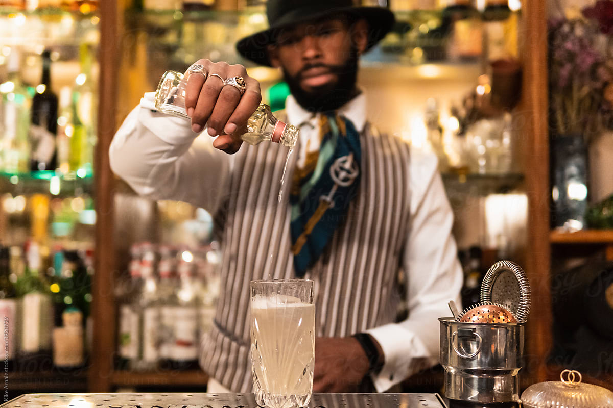 Stylish barman preparing alcoholic cocktail in bar