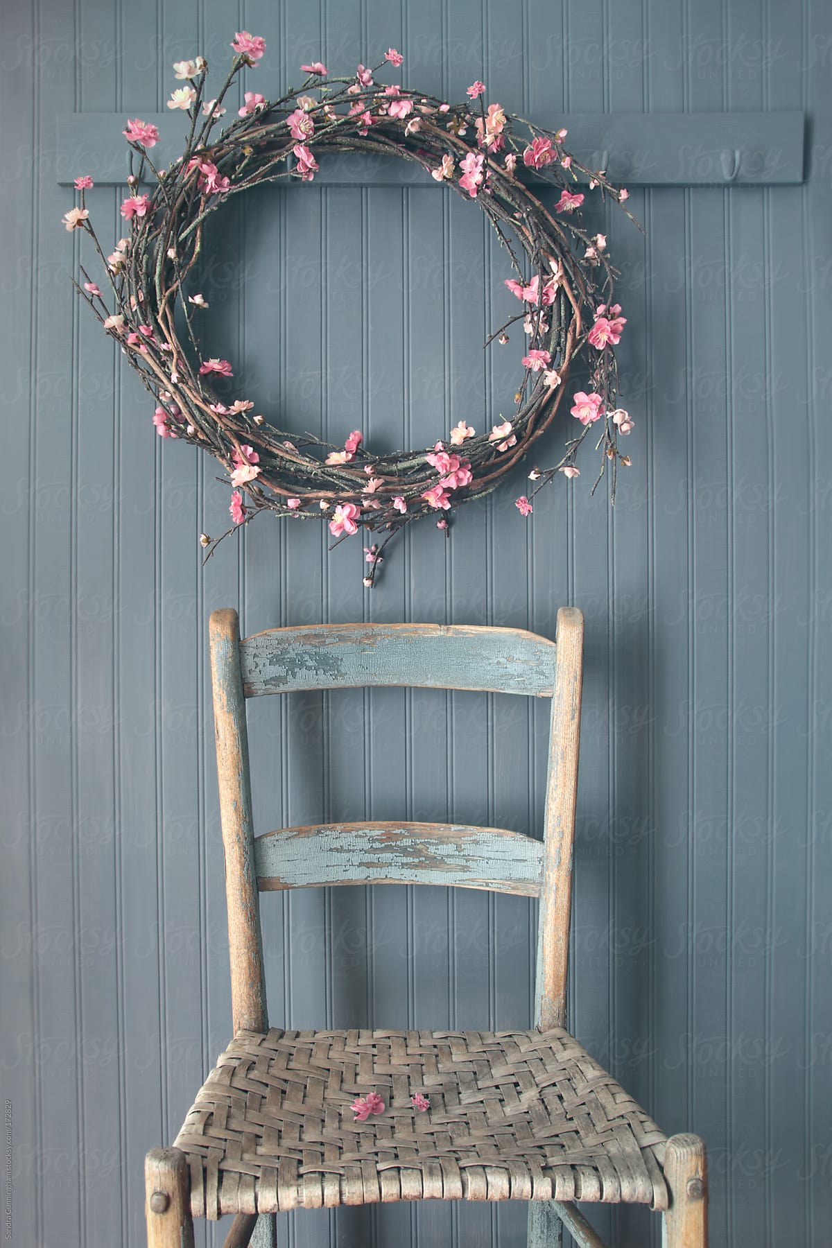 Apple blossom wreath hanging on coat hook with chair