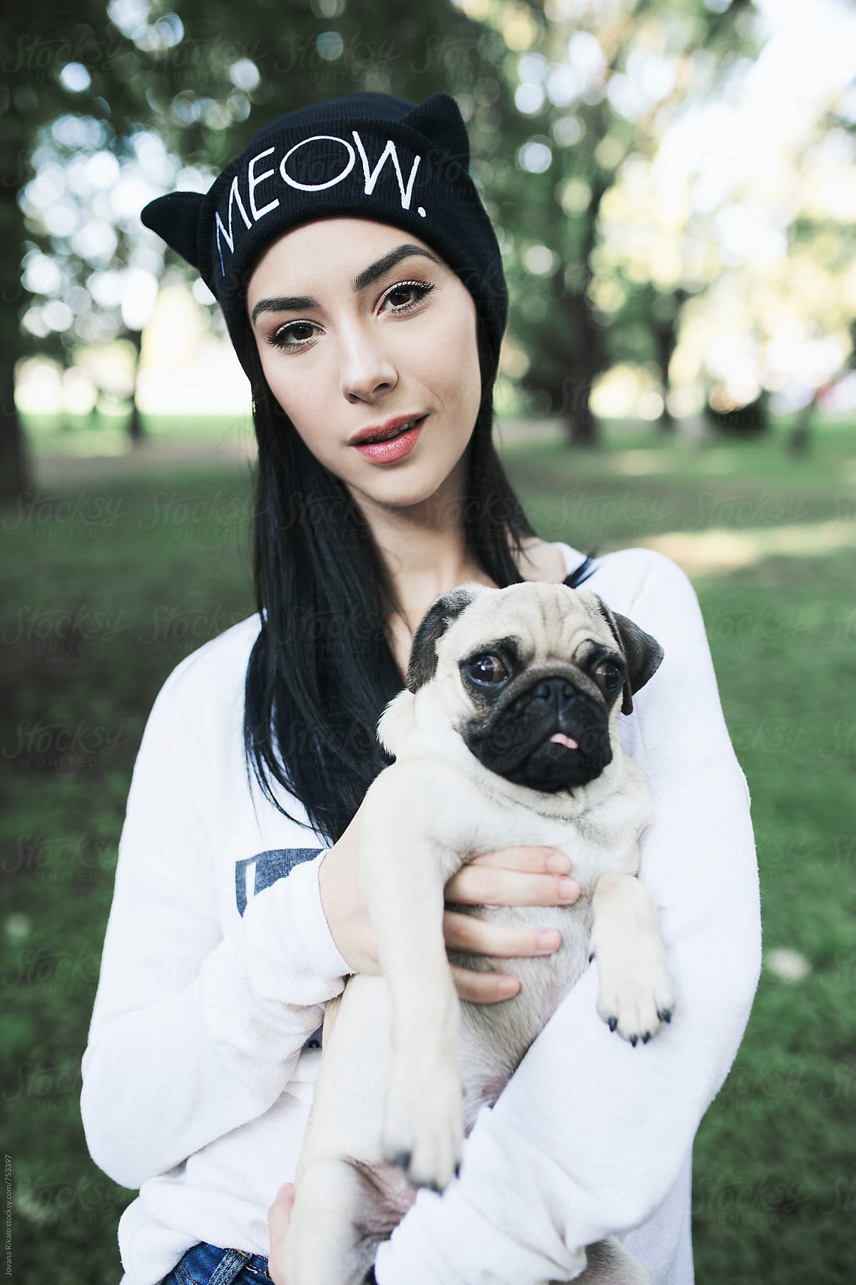 Portrait of a young woman and a pug dog